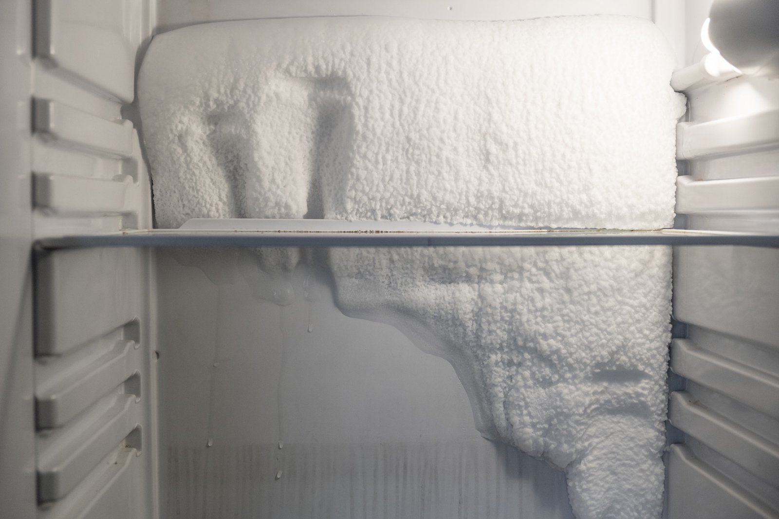 Stark vereister Gefrierschrank mit dicker Eisschicht